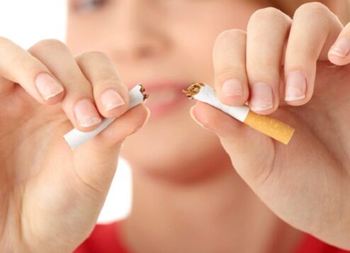 Une fille casse une cigarette et arrête de fumer